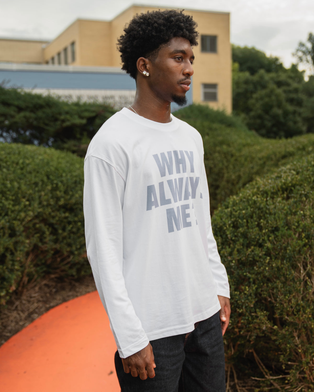 Model wearing white Why Always Me long-sleeve shirt with light blue lettering by MADEBYFUTBOL