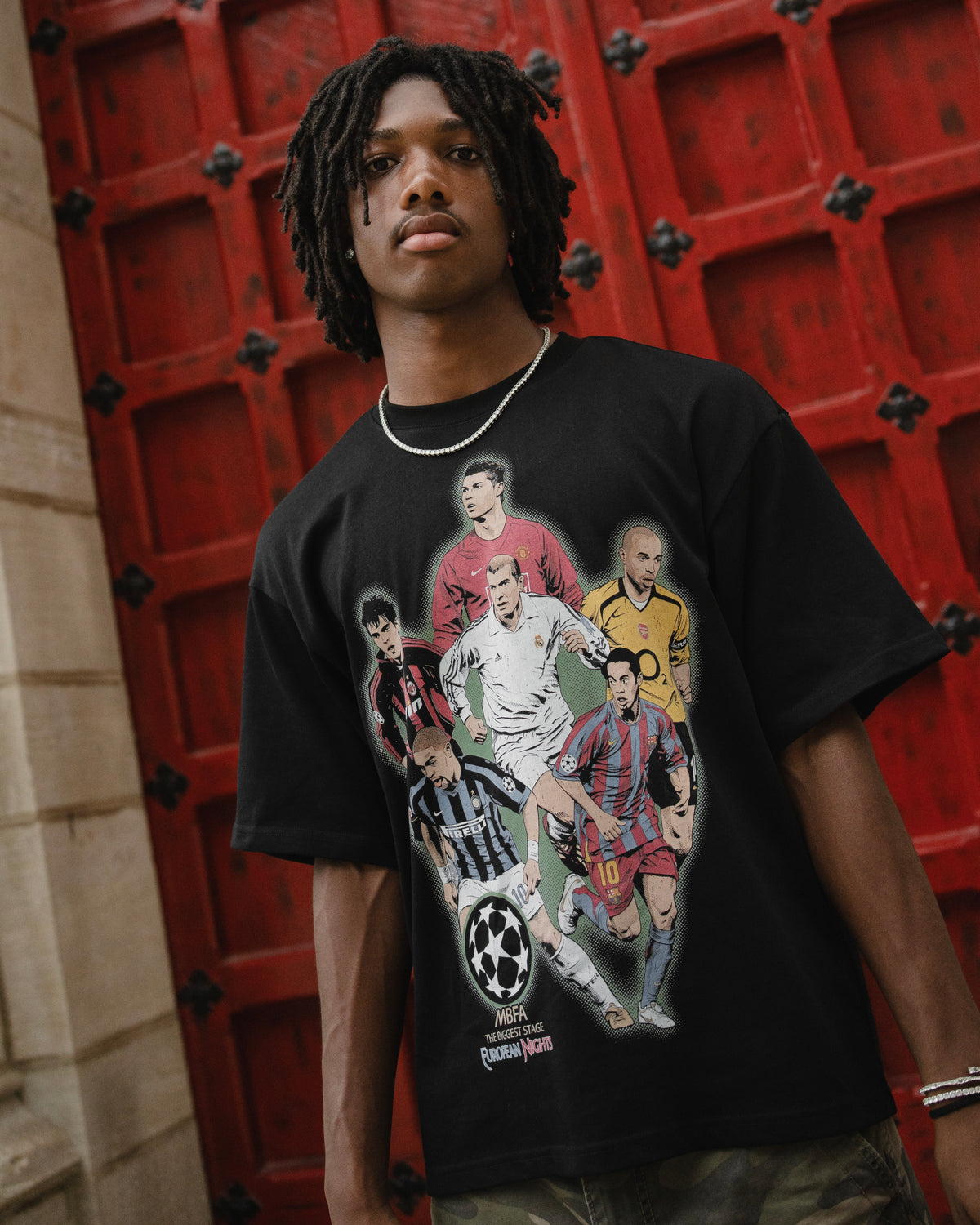 Model wearing black UCL Royalty graphic T-shirt by MADEBYFUTBOL