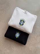 Folded white and black Brazil hoodies with chest crests by MADEBYFUTBOL