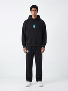 Model wearing black Brazil hoodie and matching sweatpants by MADEBYFUTBOL